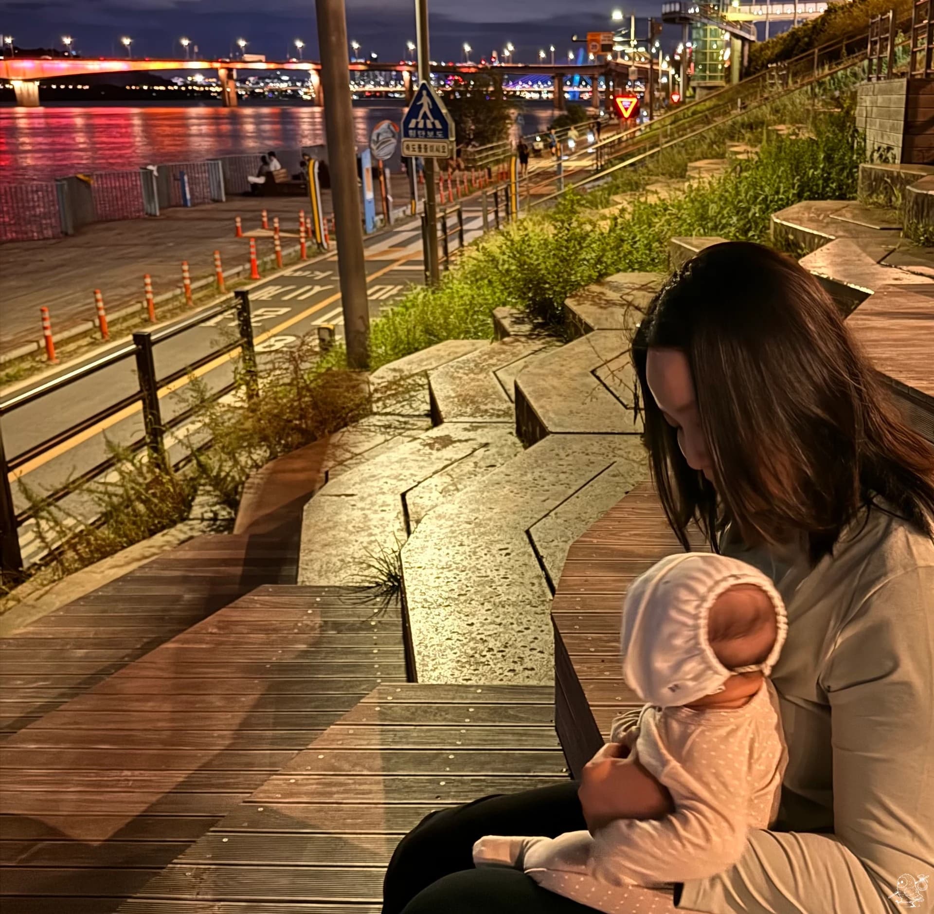 Le bébé regarde attentivement les passants, tandis que ma femme l'observe avec un sourire satisfait Le bébé regarde attentivement les passants, tandis que ma femme l'observe avec un sourire satisfait